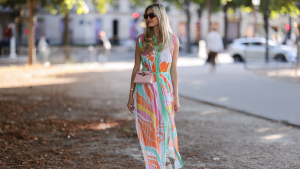 Mandy Bork seen wearing brown sunglasses from Tom Ford, a colorful buttoned / pleated / sleeveless long dress from Emilio Pucci, a pale pink Hermes Kelly mini bag and white creme sandals from Chanel, during Paris Fashion Week - Haute Couture Fall Winter 2022 2023, on July 06, 2022 in Paris, France.