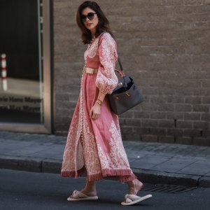 DUSSELDORF, GERMANY - JULY 24: Ira Meindl is seen wearing a rose, pink and white printed long Zimmermann dress with a beige belt, a black leather handbag from Hermes, black Saint Laurent sunglasses and beige Catwalk slipper on July 24, 2022 in Dusseldorf, Germany. (Photo by Jeremy Moeller/Getty Images)